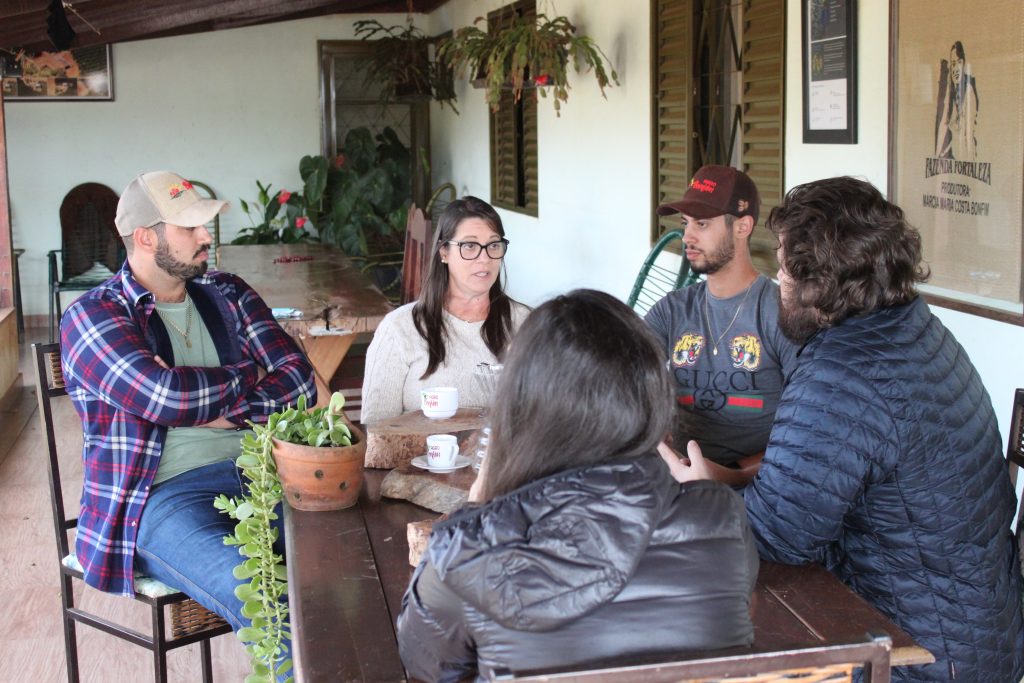 Foto da família Bonfim junto com a equipe Veroo ao redor da mesa em uma boa prosa